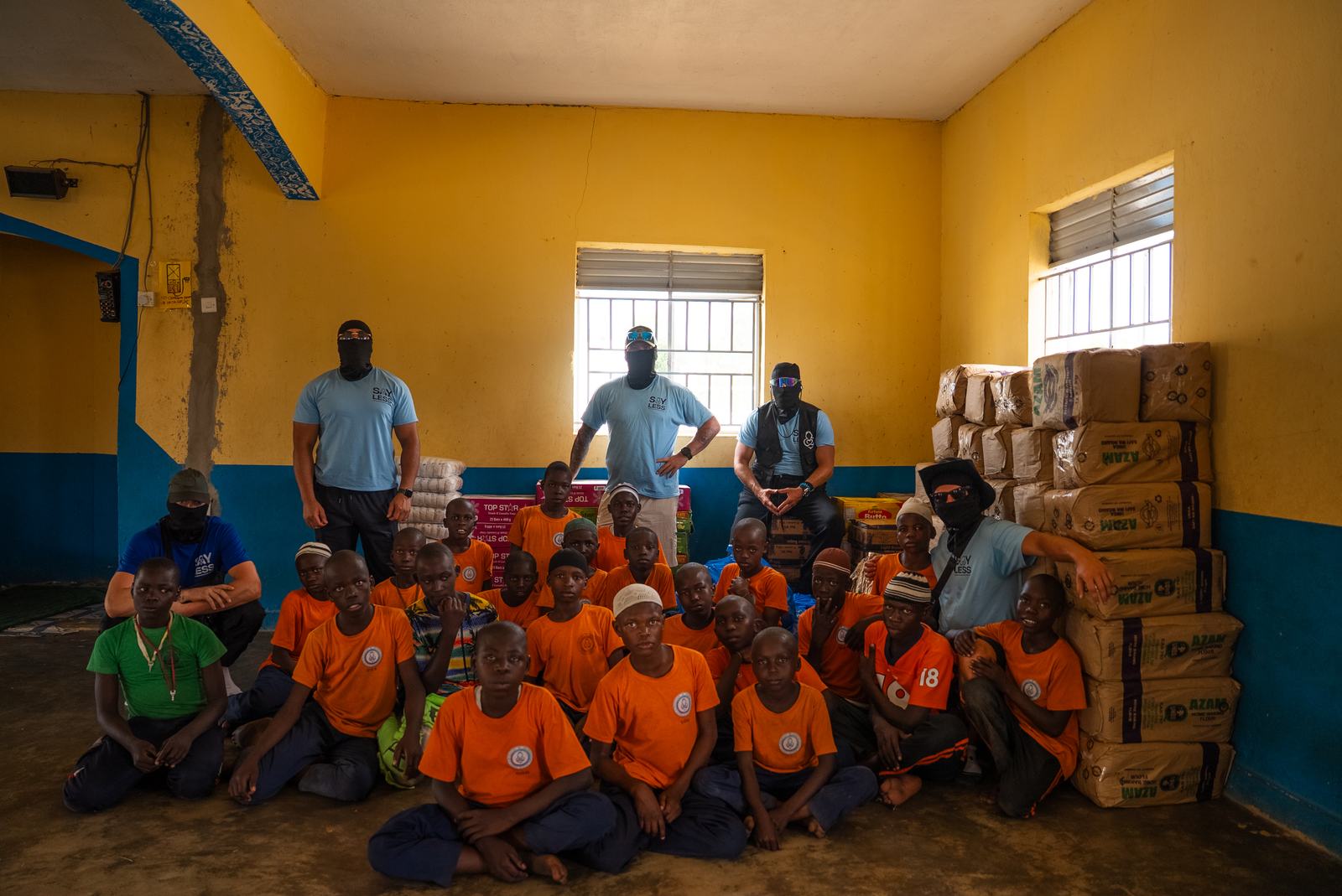 Helpers and pupils gathered together beside donated supplies
