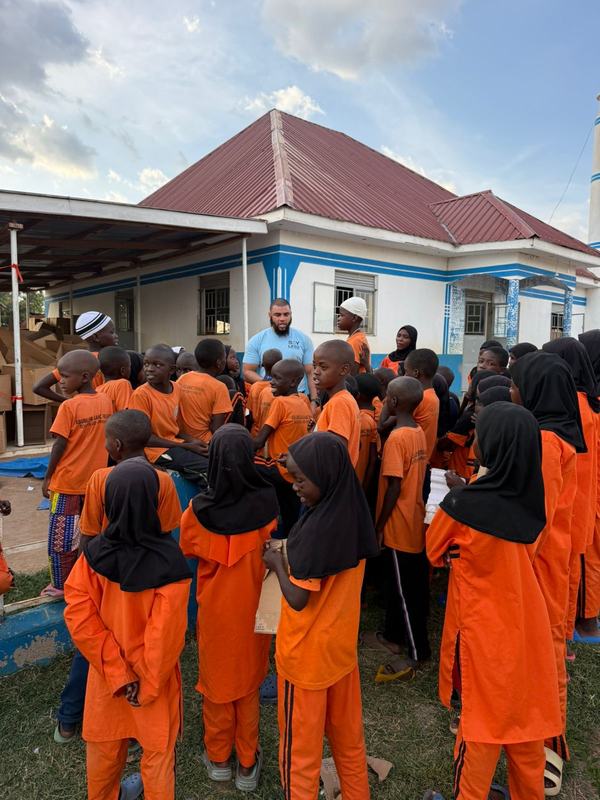 Pupils in orange uniform outside a school building