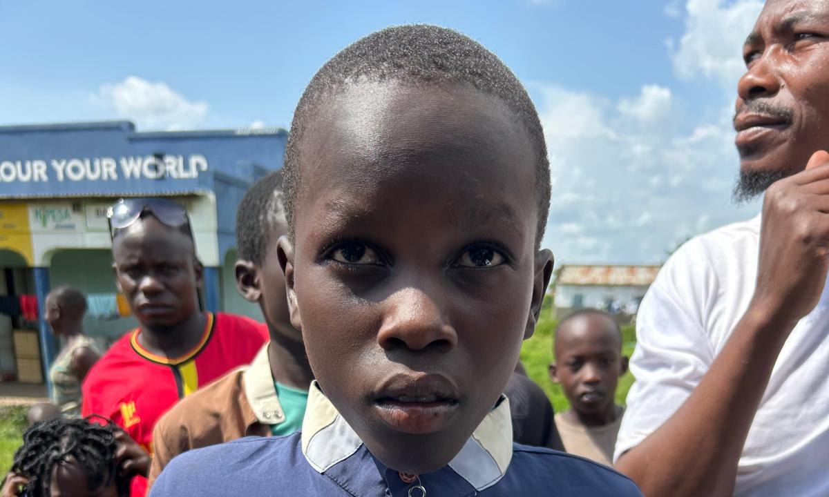 A boy in a school jumper among other children