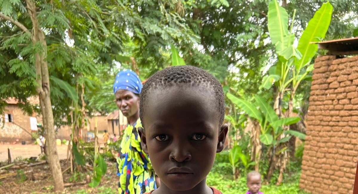 A boy standing in front of trees