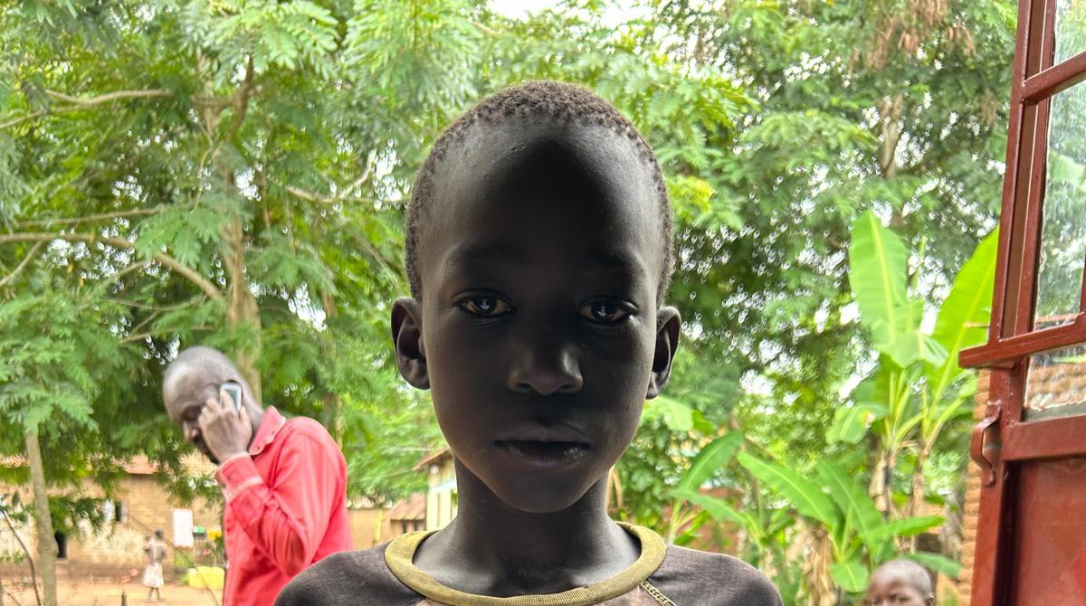 A boy in front of banana trees