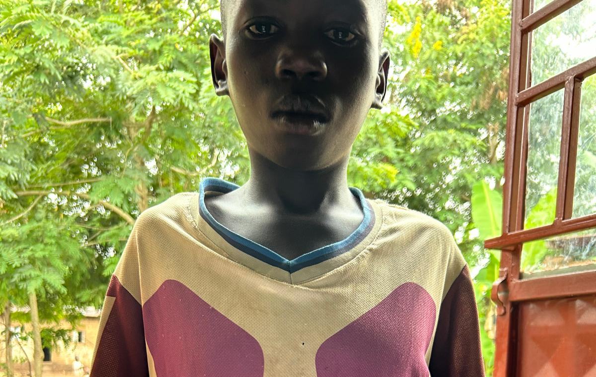 A boy standing by an open door