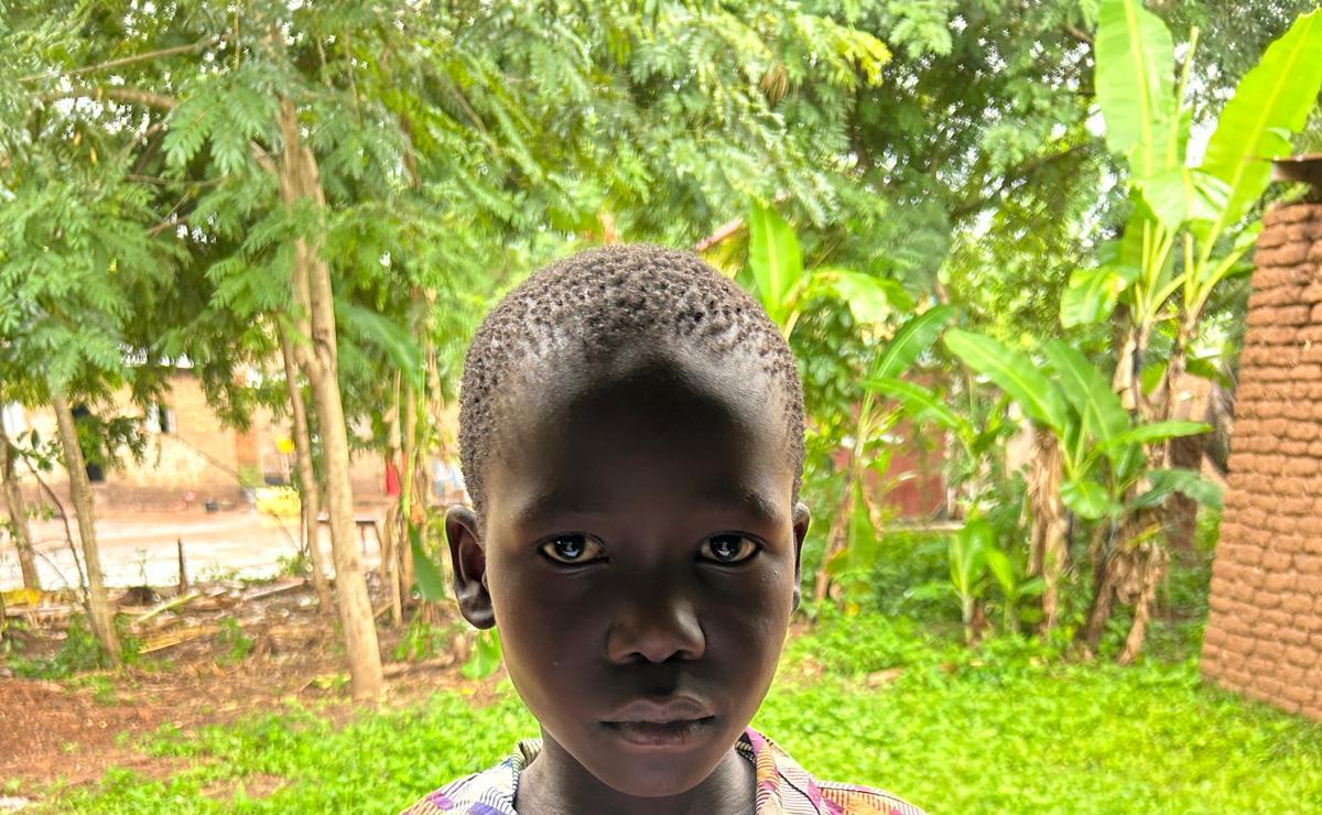 A boy standing in front of banana trees