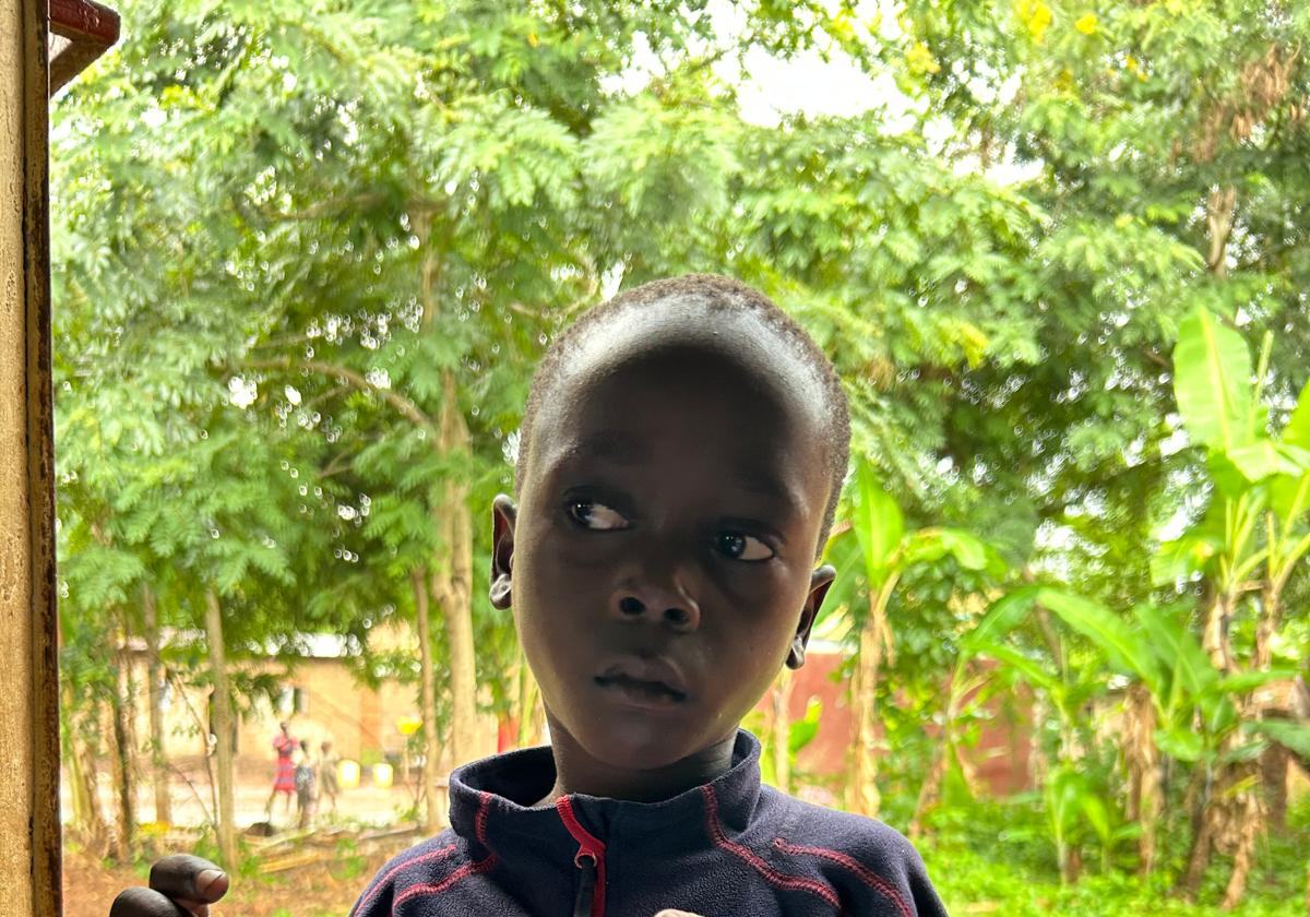 A boy in a dark jumper outside