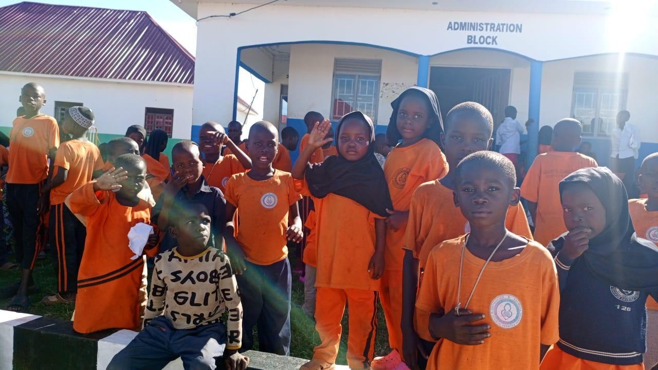 Pupils in orange uniforms outside the school administration block