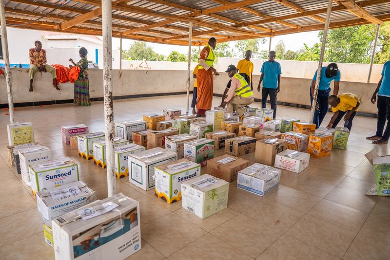 Donated school supplies laid out under a shelter